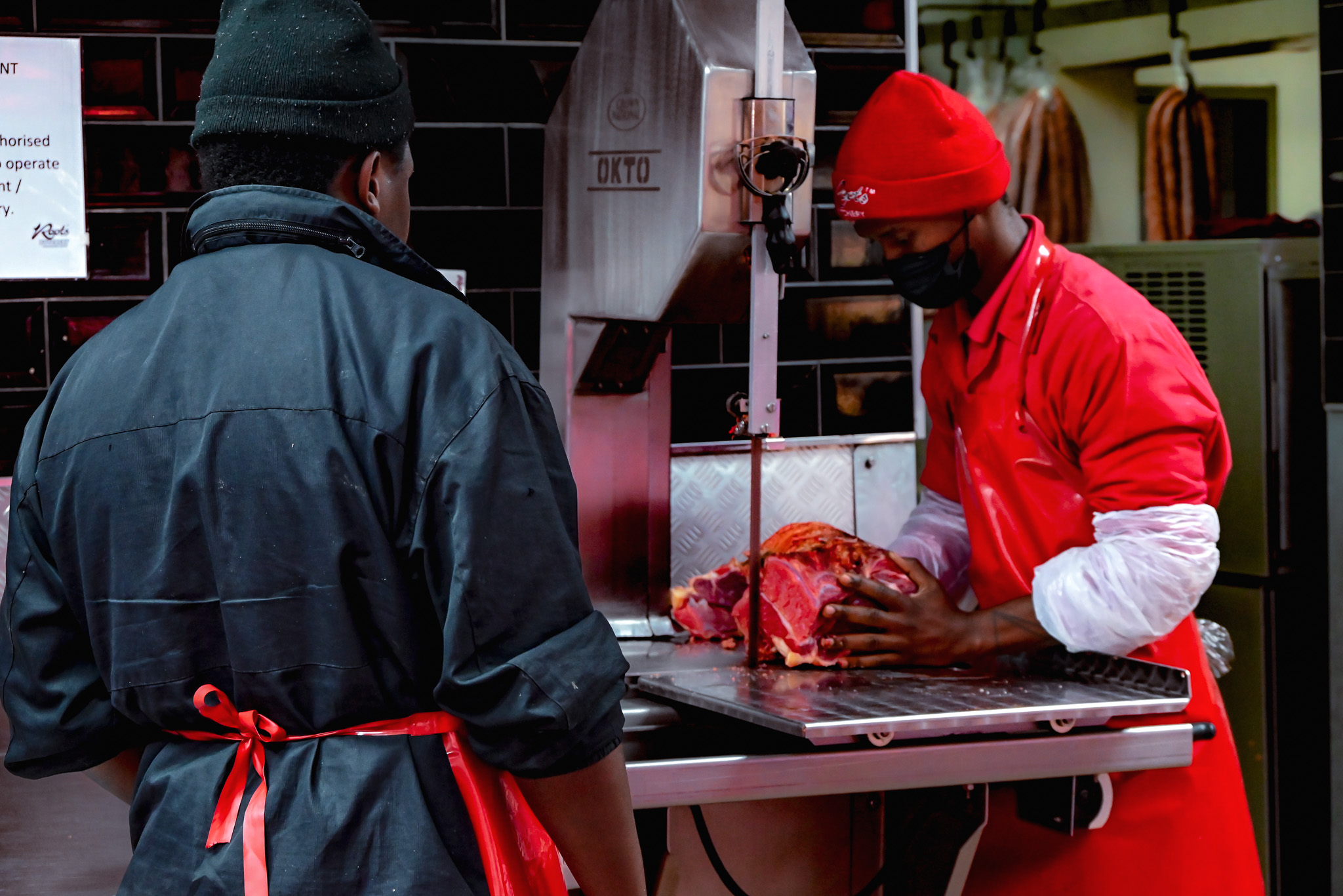 Roots Butchery butchers cutting meat on a bandsaw