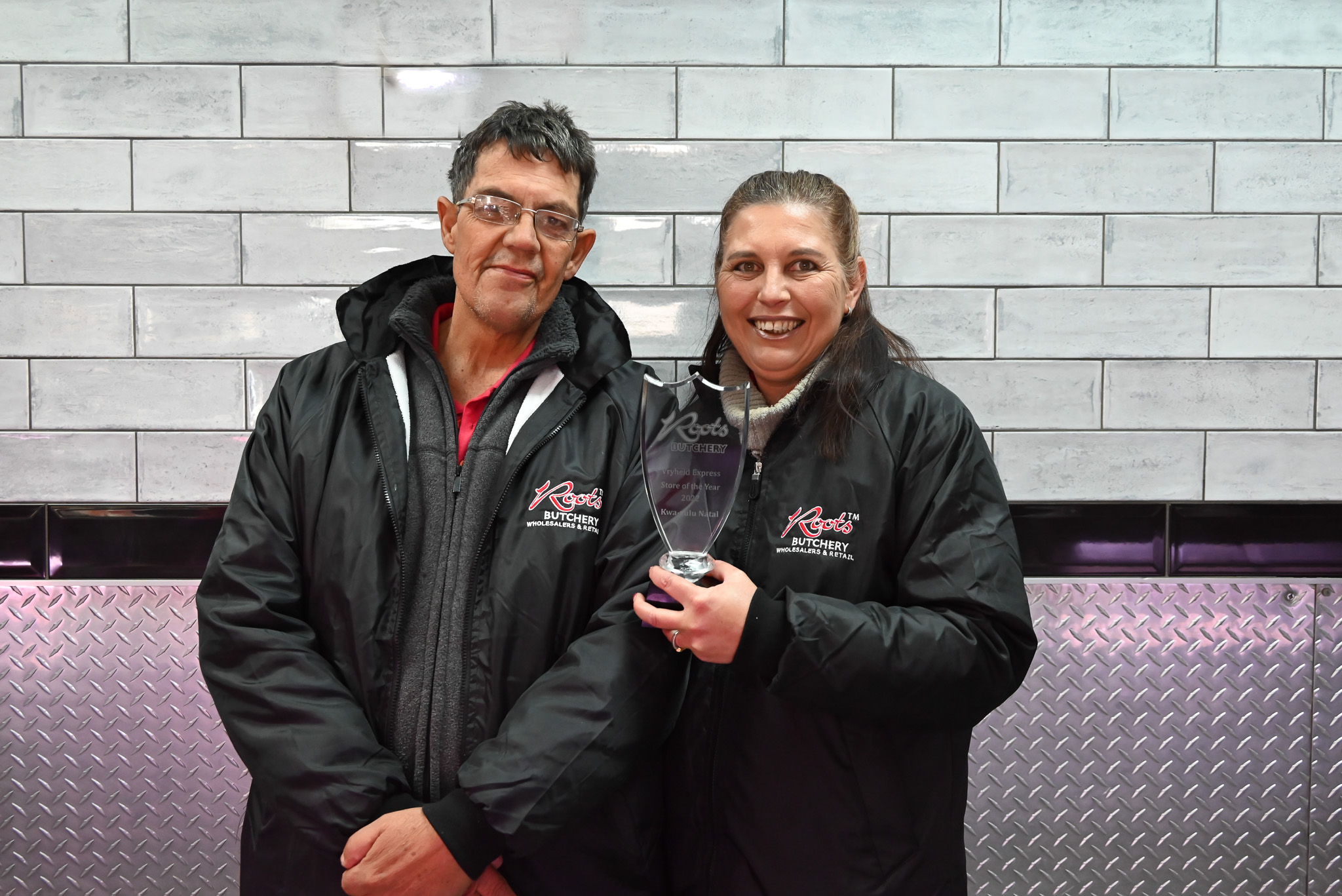 Roots X Press management, Kobus Kriel and Lize Booth, holding an award